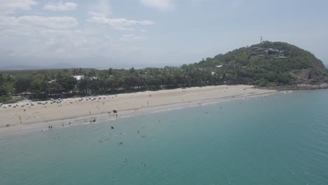 Vista-Aérea-De-Los-Turistas-Nadando-Y-Caminando-En-La-Playa-De-Cuatro-Millas-En-Fnq,-Australia