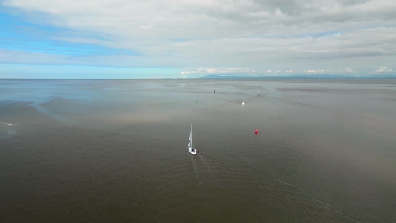 Yachts Heading In And Out To Sea On Calm Waters On Sunny Day. Camera Slow Orbit With Slight Tilt. River Wyre Estuary, Fleetwood, Lancashire, UK