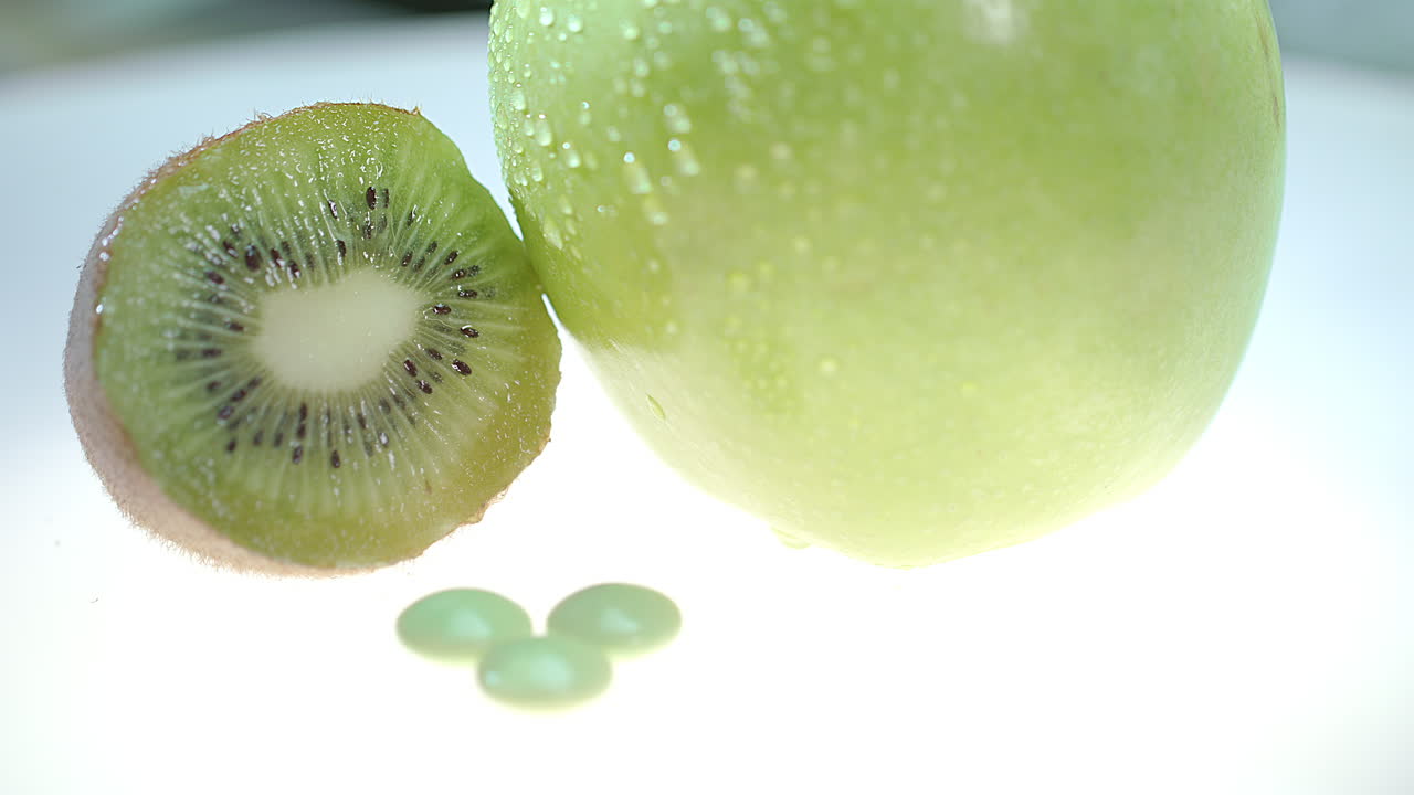 kiwi verde e frutas de maçã com comprimidos de vitaminas. pílulas de vitaminas de verão