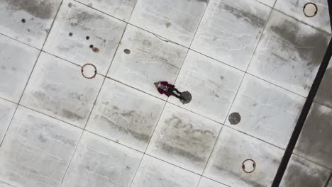 lonely man laying on cold concrete ground empty road vertigo drone effect zoom out small earth