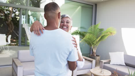 Biracial-couple-embraces-warmly-in-a-modern-outdoor-setting