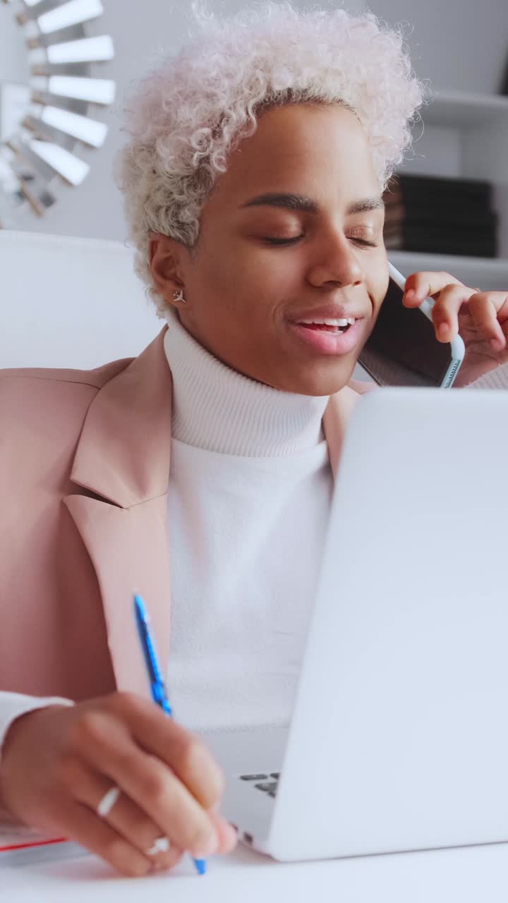 Young professional engaged in a phone call while working at a desk