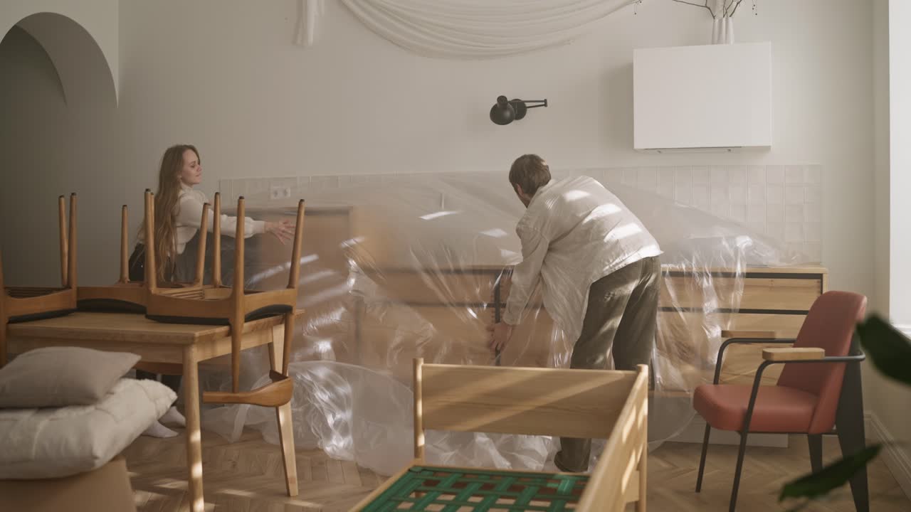 pareja moviendo muebles en la cocina remodelación