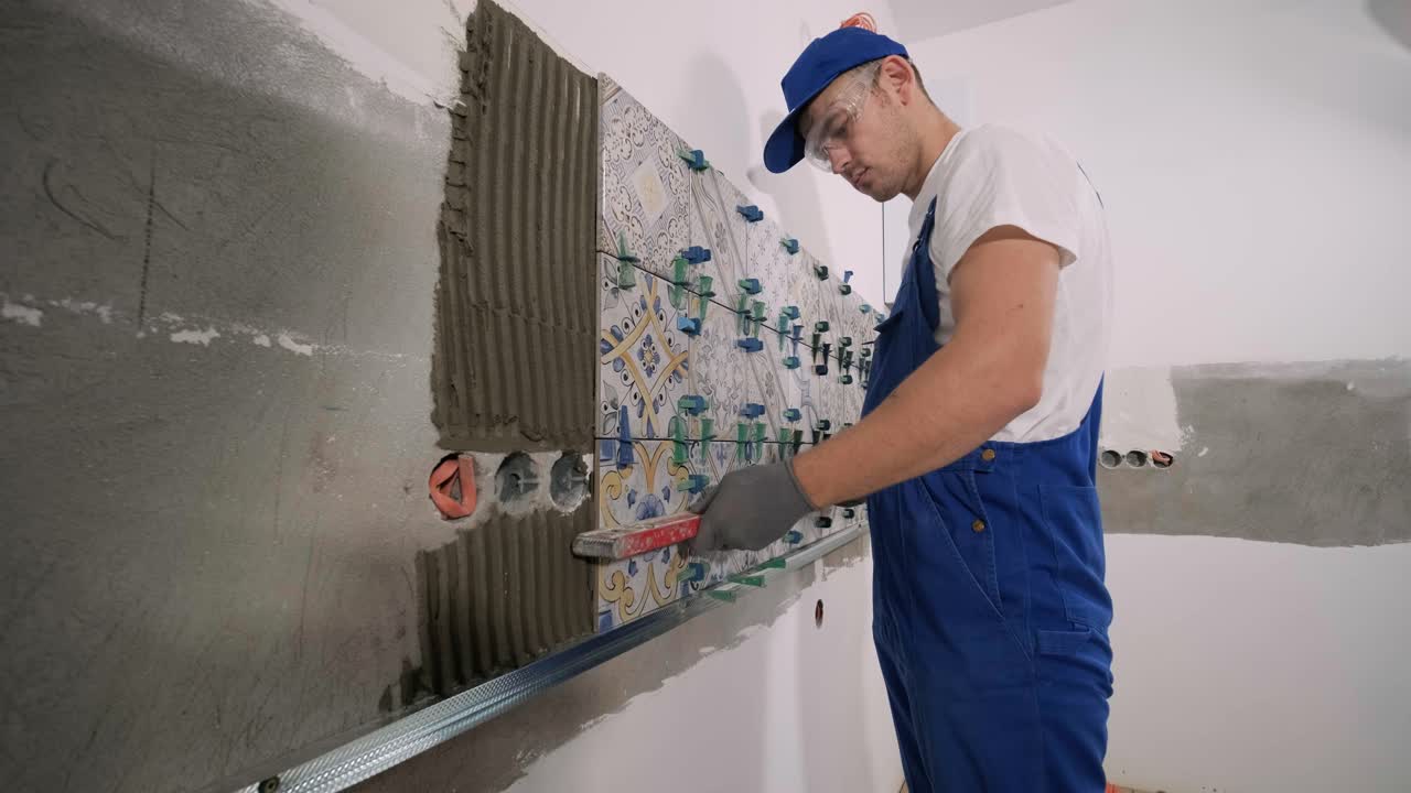 Installing ceramic floor tiles - measuring and cutting the pieces. Construction, renovation, repair apartment. Cuts tile. Tile cutting