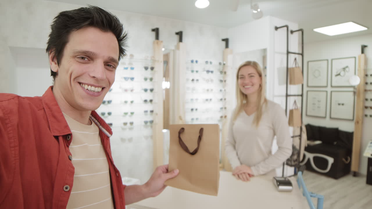 cliente feliz recogiendo gafas en una tienda de óptica