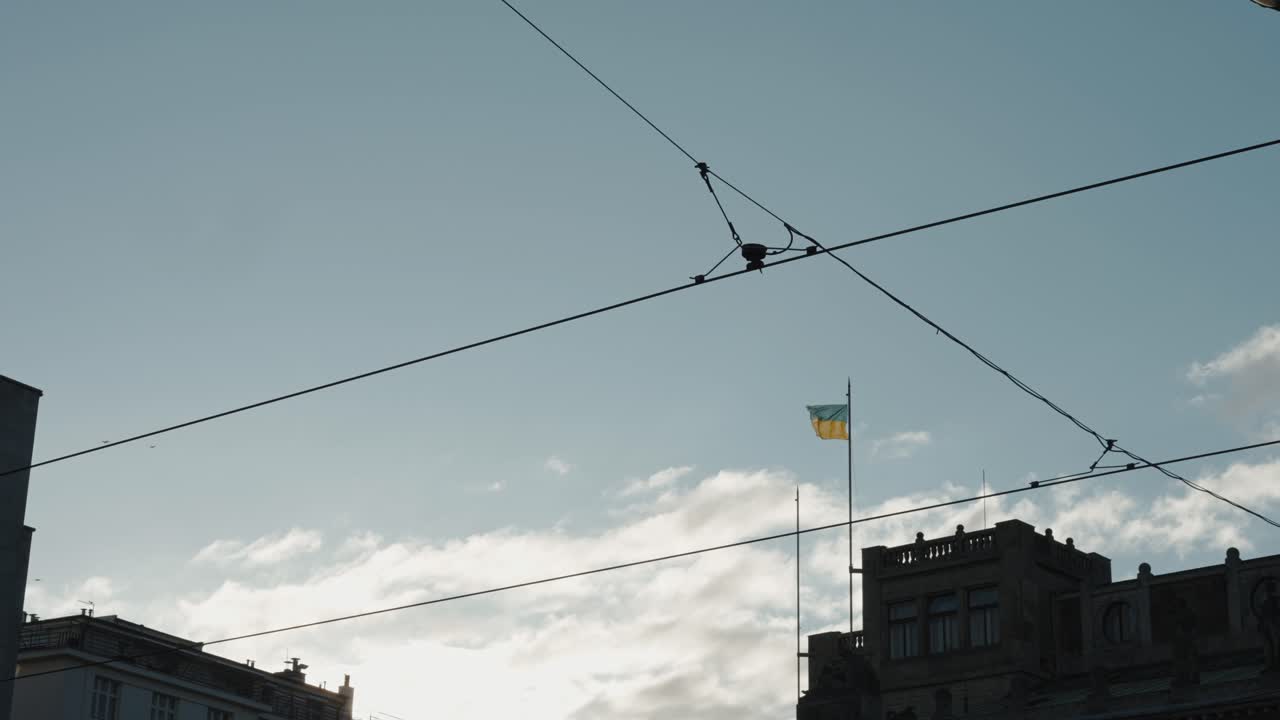 European city street with tram wires and the Ukrainian flag prominently displayed