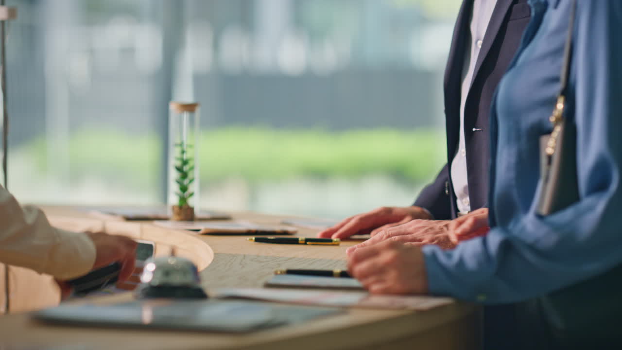 클로즈업 클라이언트 손이 휴대전화로 접촉없이 지불합니다. 호텔 손님들이 체크인합니다.