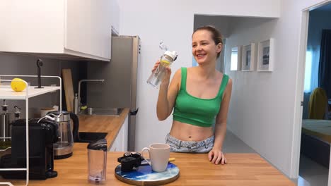 woman drinking water in kitchen