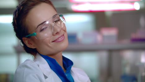 mujer químico sonriendo. primer plano de la cara de la mujer químico en gafas de seguridad