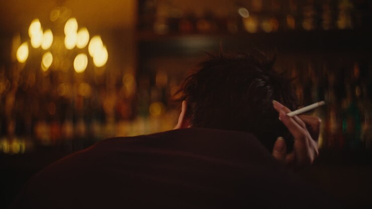 Man Smoking at a Bar at Night