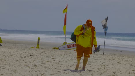 lifesaver carrying equipment on sandy beach