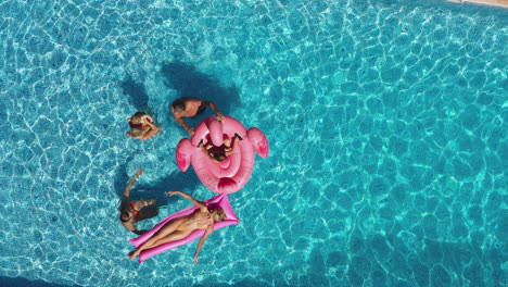 fotografía aérea de una familia multigeneracional con inflables en vacaciones de verano en una piscina