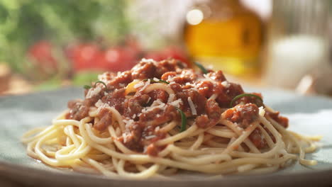 espagueti bolognese servido con romero en un plato - presentación del plato principal en un soleado restaurante italiano, packshot, dolly out