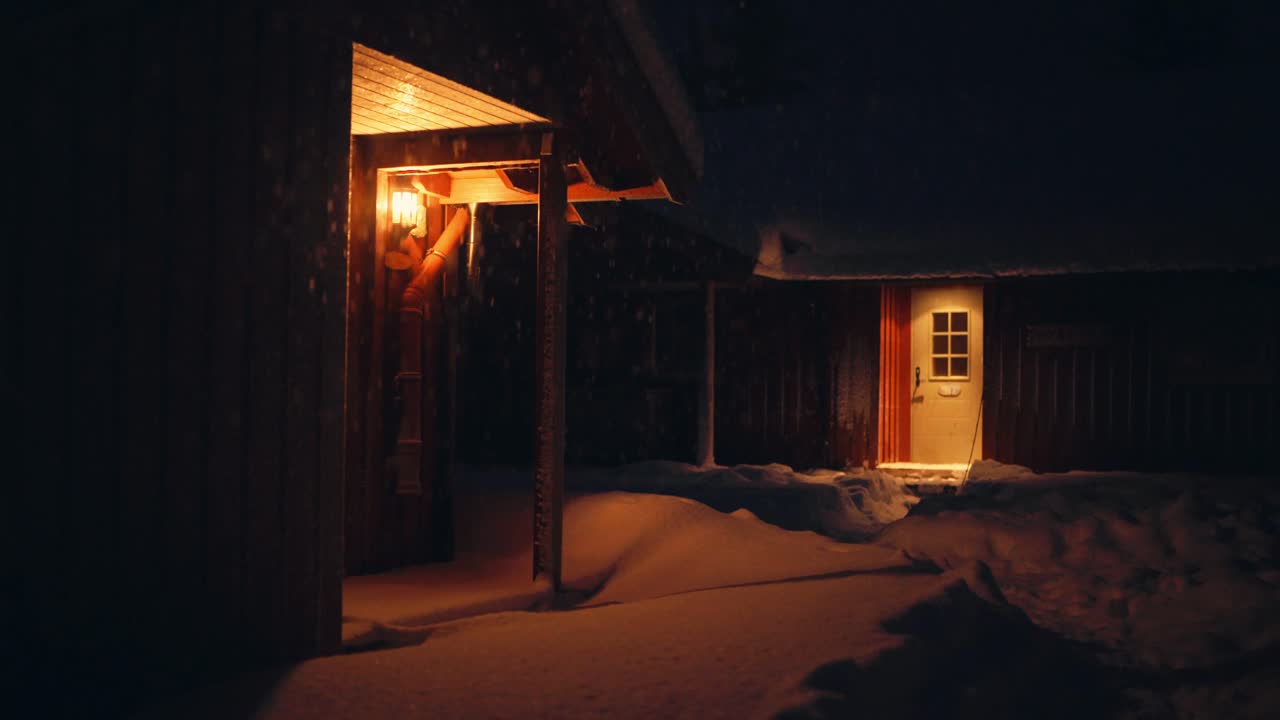 눈이 내리는 겨울 밤에 조명이 켜진 롯지