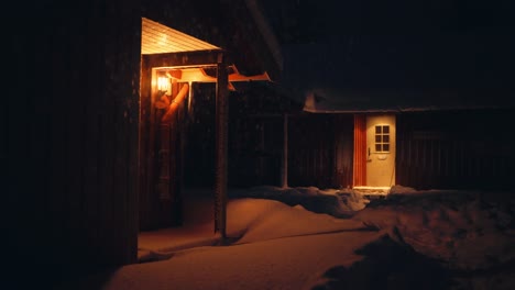 illuminated lodges on winter night with falling snow