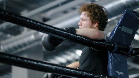 sad kickboxer losing fight at gym. upset sportsman standing on ring