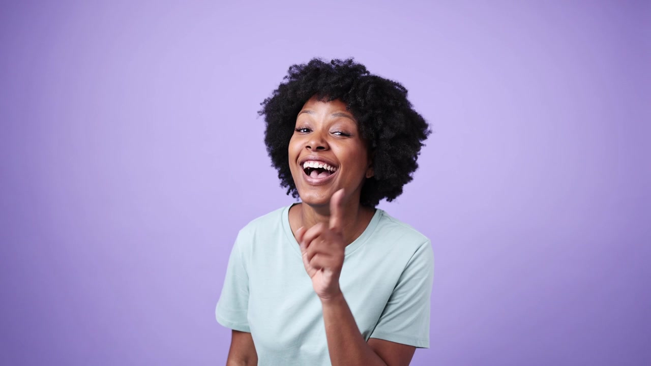 Wanita Afrika-Amerika yang ceria mengedipkan mata, memberi isyarat untuk diam, dan menunjuk