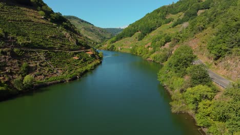 Tranquil-Waters-Of-Miño-River-Along-The-Mountains-With-Terraced-Fields