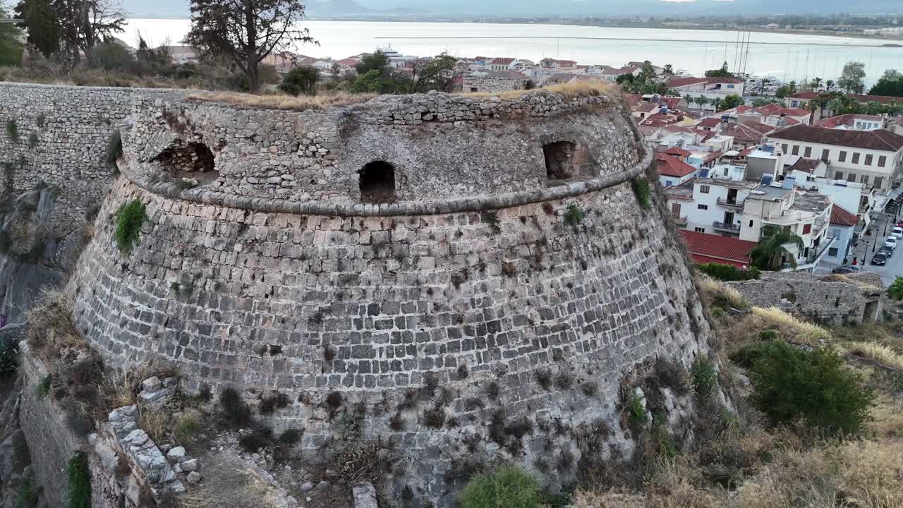 Peloponneso, Nauplia, vista aerea frontale e panoramica circolare a destra attorno alla fortezza di Acronauplia durante il tramonto. Dietro si trovano la città di Nauplia e la baia.