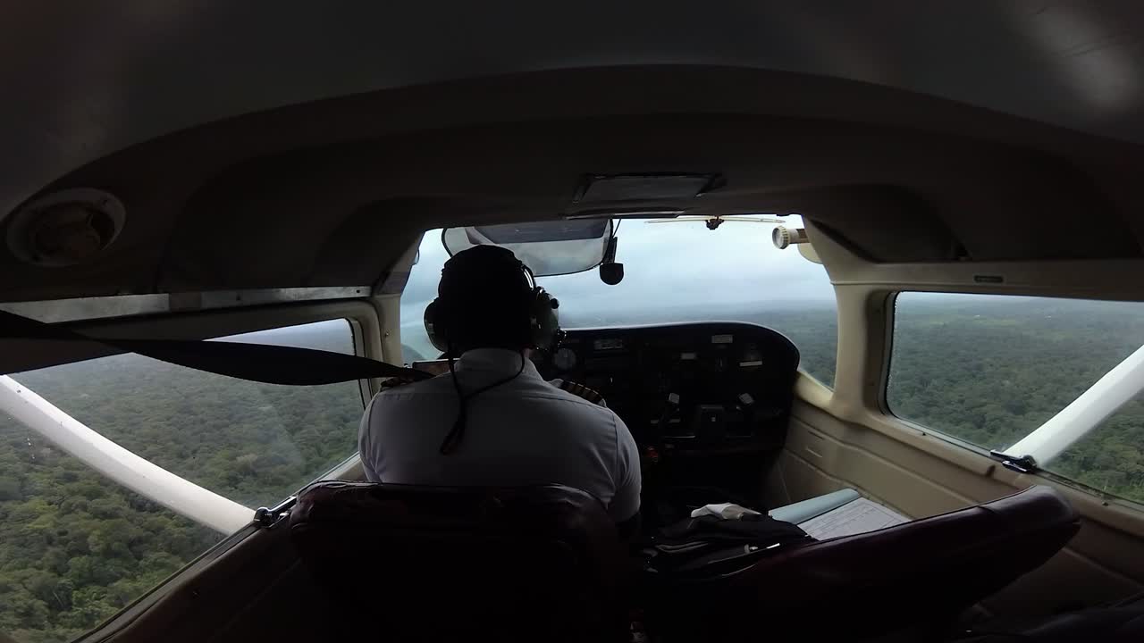 Pilot flying through remote jungle in Cessna Aircraft.