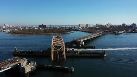 A-aerial-shot-of-a-swing-bridge-opening-on-a-bay-in-Queens,-NY