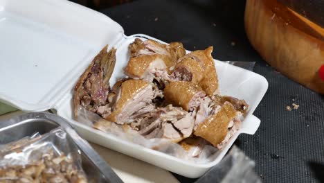 close-up footage of street vendor putting chinese stewed duck in the packaging