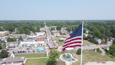 USA-flag-and-township-of-New-Baltimore,-aerial-drone-view