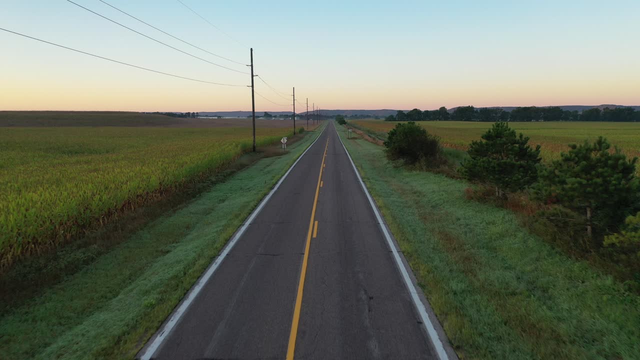 Strada rurale all'alba attraverso i campi