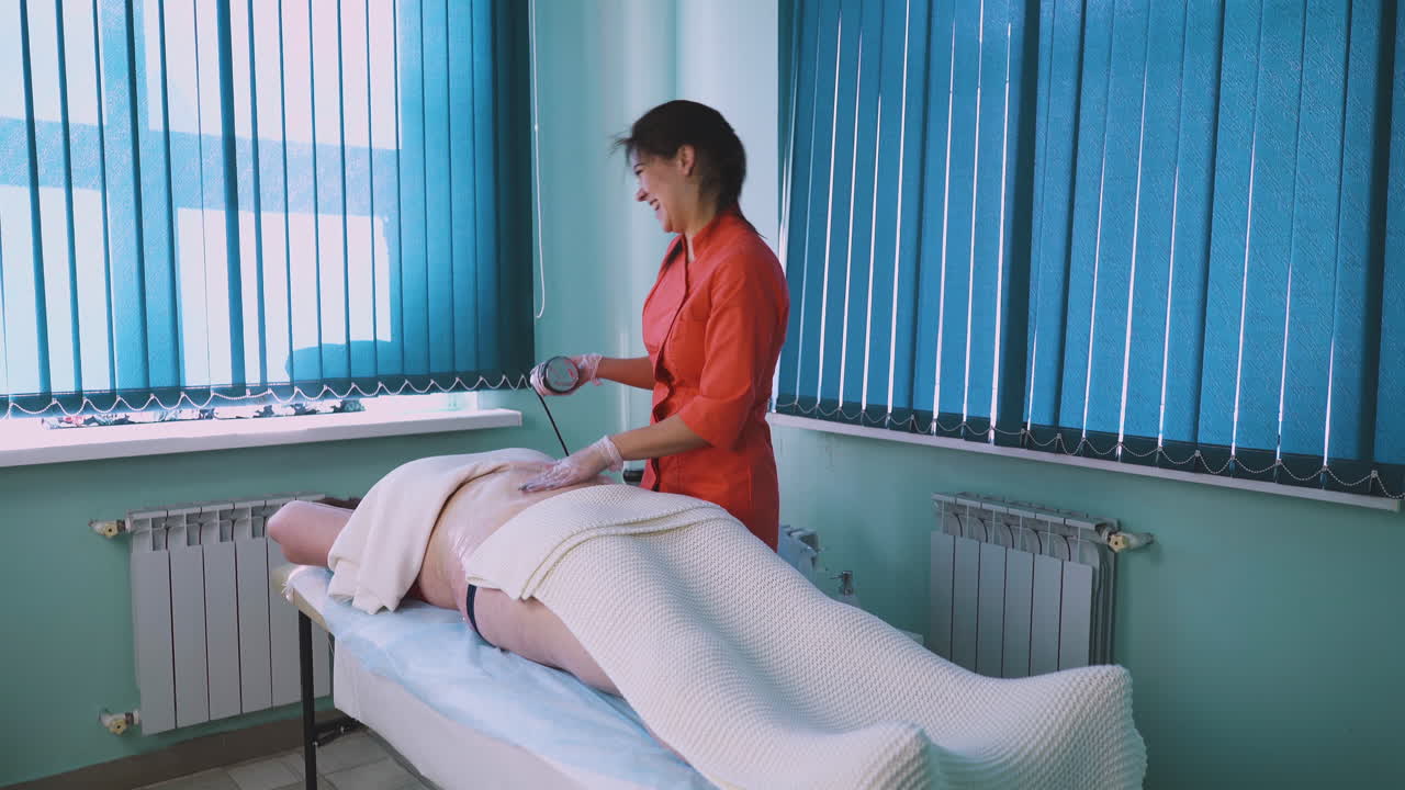 esteticista em uniforme trabalha com uma mulher de tamanho grande na clínica