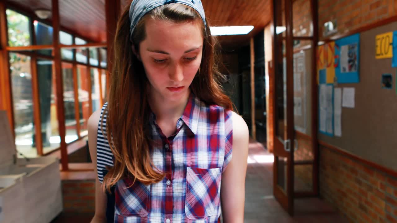 estudiante leyendo un libro mientras camina por el pasillo