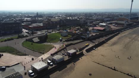 Popular-seaside-Rhyl-resort-town-promenade-aerial-view-above-coastal-beach-fairground-attraction