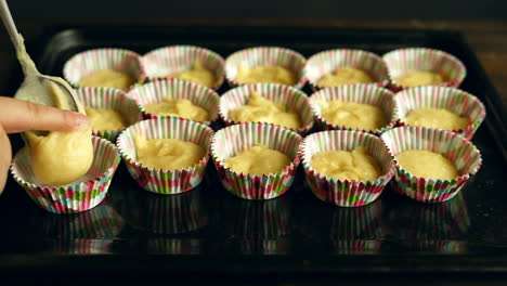 chef put dough into baking tray. muffin cake preparation. cooking muffins