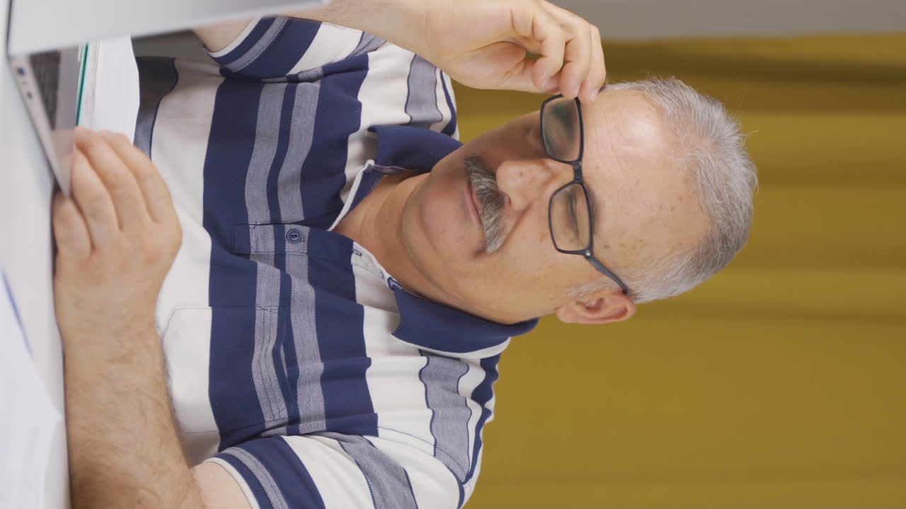 video vertical de un trabajador de oficina en casa, un anciano pensando en problemas de la vida privada.