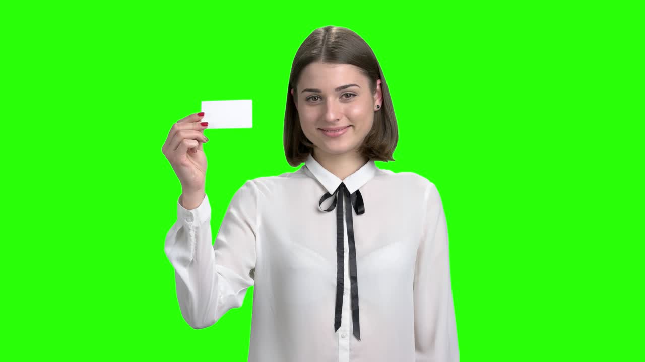 una joven linda muestra una tarjeta de visita en blanco.