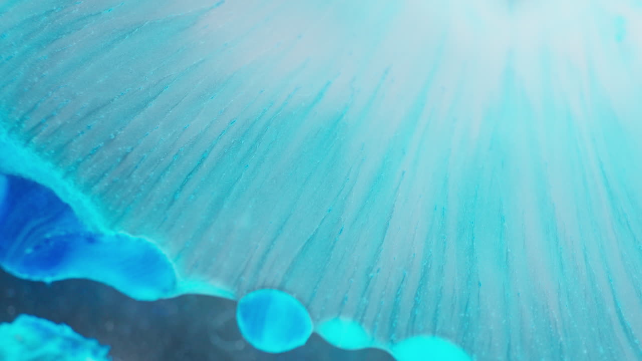 Amazing effect of turquoise ink spreading to create abstract shapes