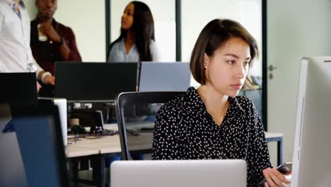 female executive using mobile phone at desk 4k