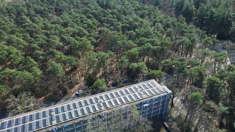 Jib-down-of-renovated-apartment-building-with-a-rooftop-filled-with-photovoltaic-solar-panels-on-a-sunny-day