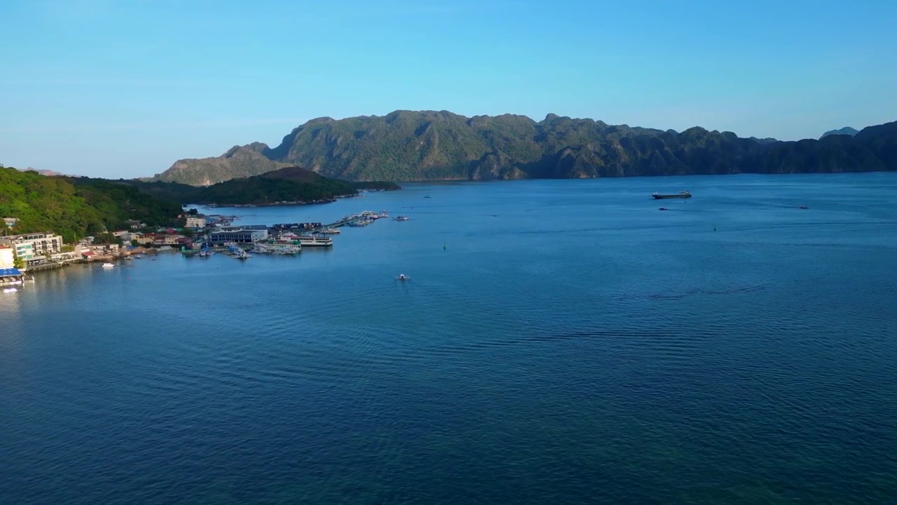 Vida urbana y barcos en la bahía de Coron, Palawan, Filipinas, durante un día soleado. Increíble vista aérea ascendente de un panorama de dron.