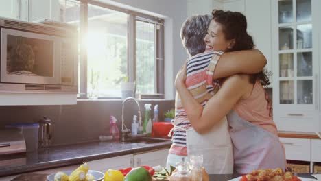 madre e hija abrazándose en la cocina 4k