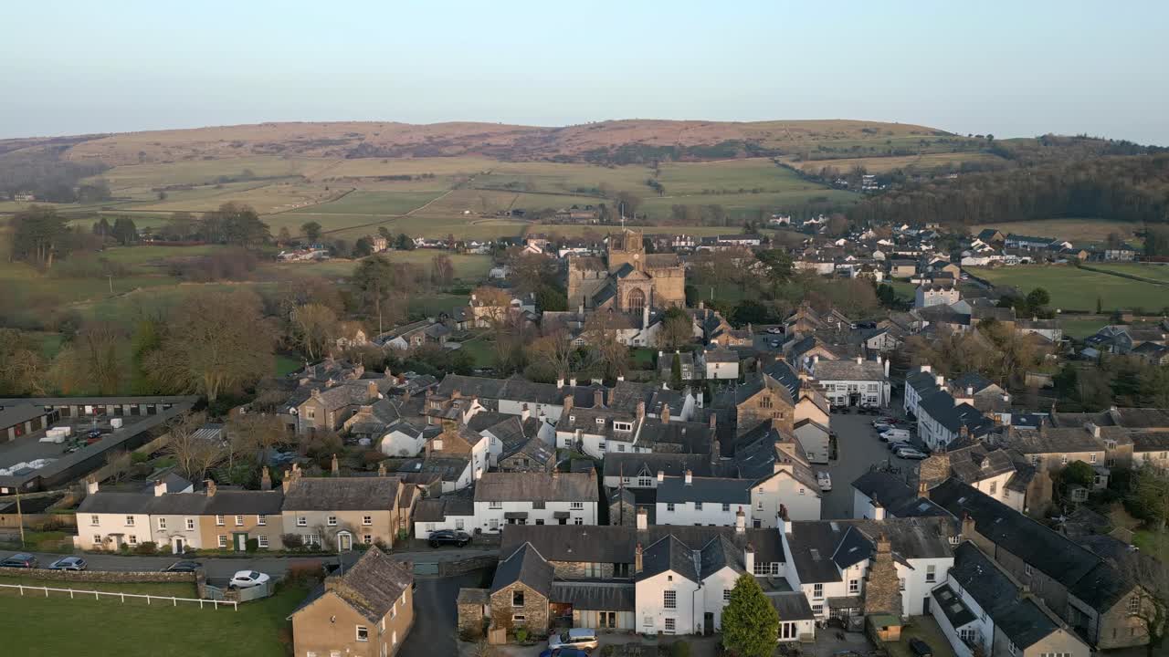clip en cámara lenta del pueblo medieval de cartmel en cumbria que muestra el histórico priorato de cartmel al atardecer en un día de invierno