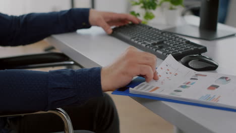 close up of handicapped entrepreneur with protective face mask analysing graphs