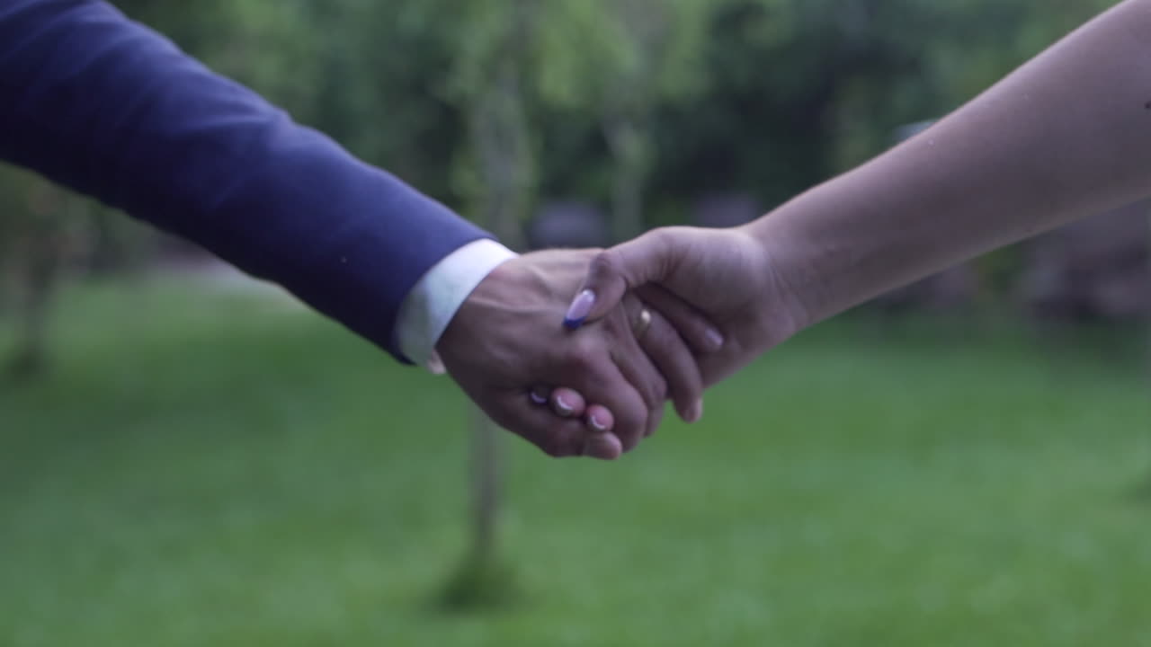 Couple holding hands, symbolic wedding gesture