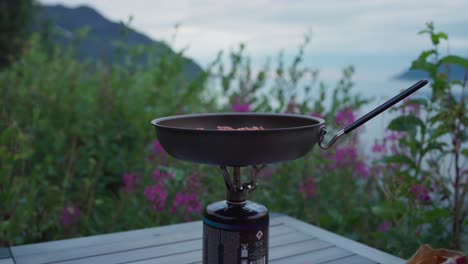 cooking backpacking meal with portable gas stove in norway