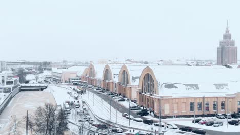 vista aérea nevada de invierno del mercado central de riga cubierto de nieve blanca, día