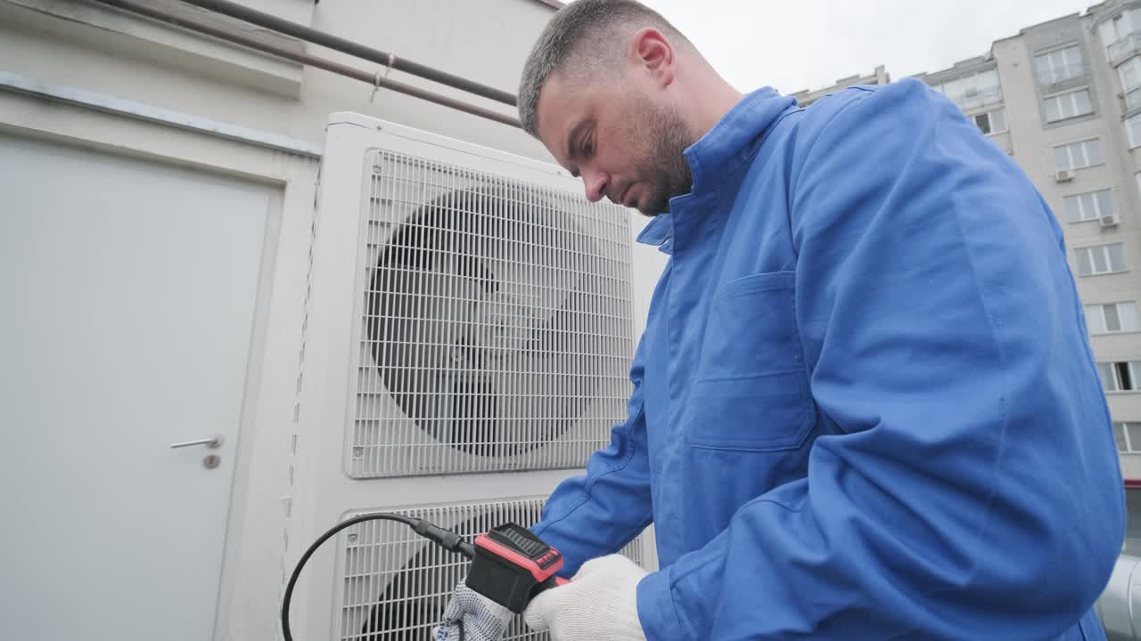 The technician uses a digital camera to check the clogging of the heat exchanger