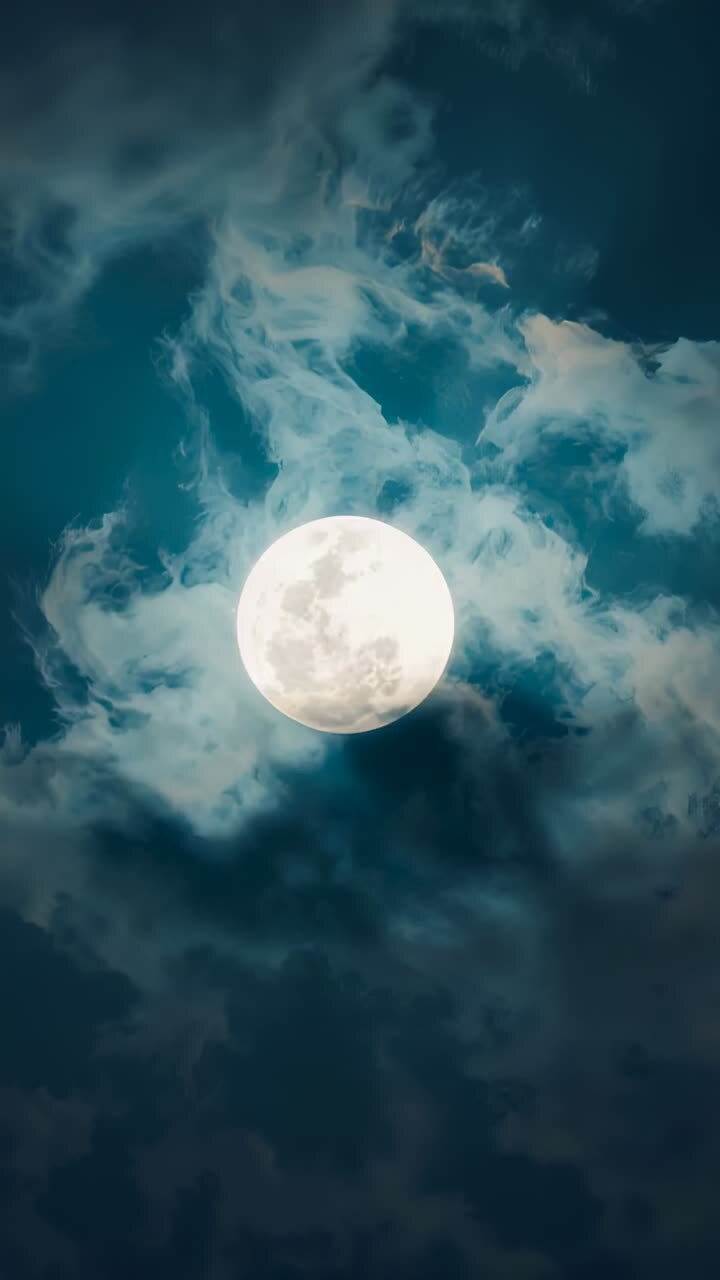 Vídeo vertical: vento soprando e movendo camadas de nuvens passando sobre a lua cheia à noite, criando um halo