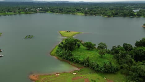 a forward-moving drone glides over greenery and water, tilting upward into a top view—revealing the full beauty of the laguna landscape in a smooth, cinematic transition