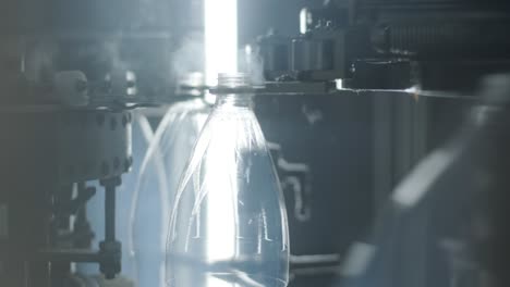 una máquina automática de llenado vierte agua en botellas de plástico en una moderna planta de bebidas