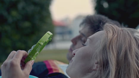 couple blowing bubbles in a park