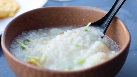 stirring and serving a bowl of savory porridge